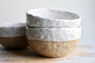 a couple of bowls sitting on top of a wooden table