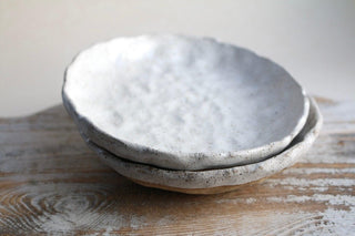 a white bowl sitting on top of a wooden table