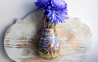 This unique rustic flower vase is inspired by magical woodland landscapes and features vibrant hand-glazed details of mushrooms and plants.