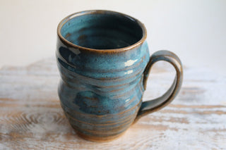 a blue mug sitting on top of a wooden table