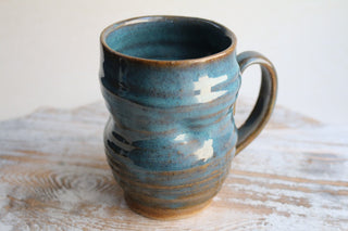 a blue mug sitting on top of a wooden table